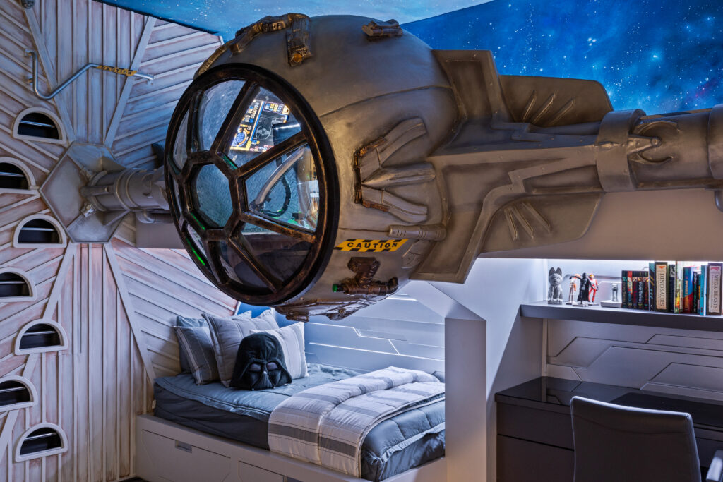 Star Wars-themed bedroom near Disney featuring a custom TIE Fighter cockpit design above the bed, complete with sci-fi lighting, detailed decor, and built-in shelving